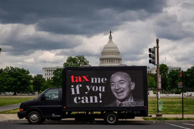 A mobile billboard with a picture of Jeff Bezos and the caption "tax me if you can."