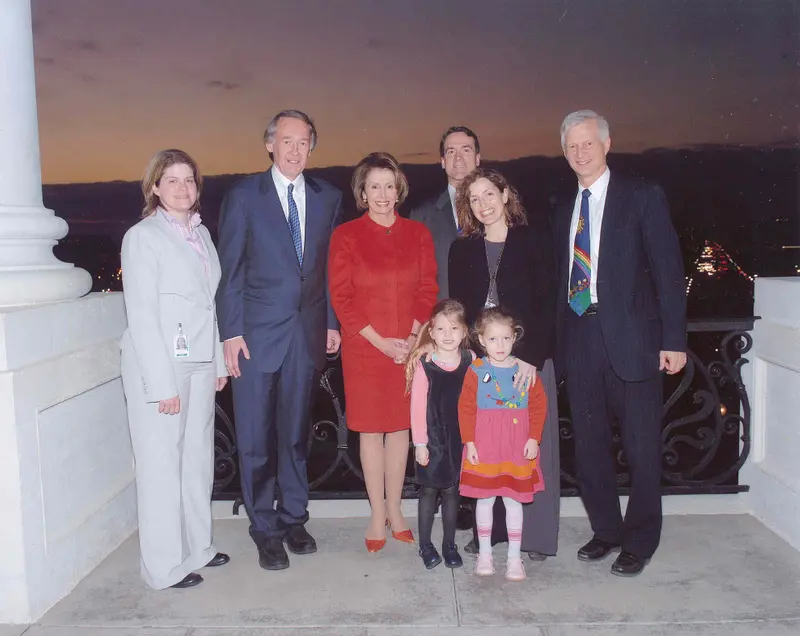 A group of six adults and two kids standing on what appears to be a balcony of the Capitol building in Washington, D.C.