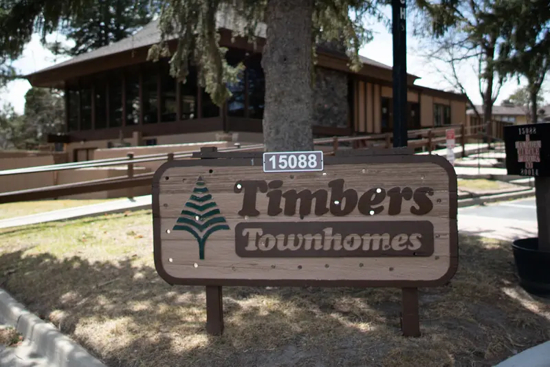 A wooden sign reading "Timbers Townhomes"