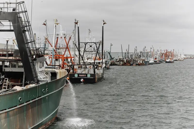 A long line of fishing boats stopped side-by-side stretches into the distance.