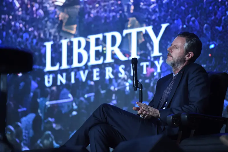 Jerry Falwell Jr. in front of a screen that says Liberty University.