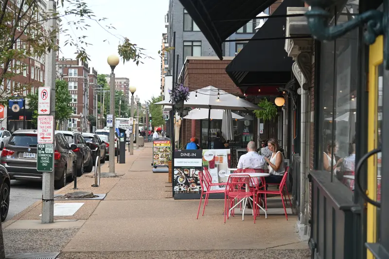 People eat at outdoors tables outside a restaurant.