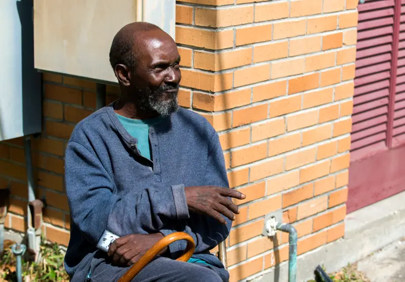 A Black man with a goatee and a cane.