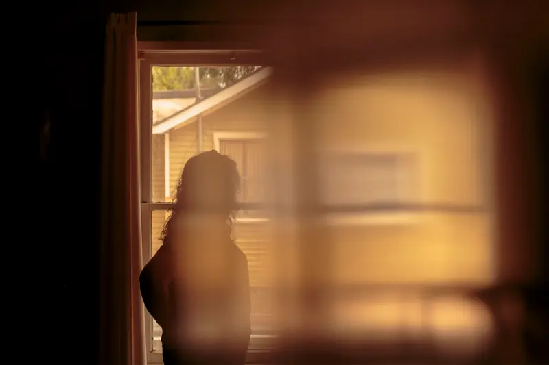 A woman stares out a window.