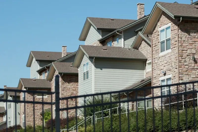 Exterior of residential buildings clad in stone and horizontal siding.