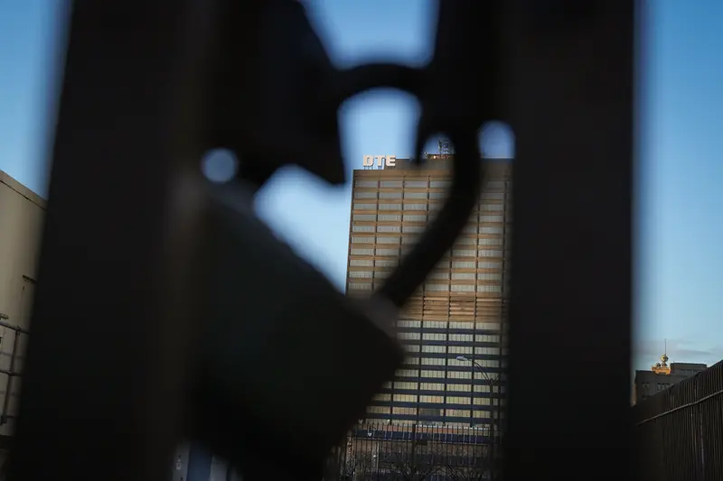 A tall office building is visible behind the silhouette of a padlock on a gate.