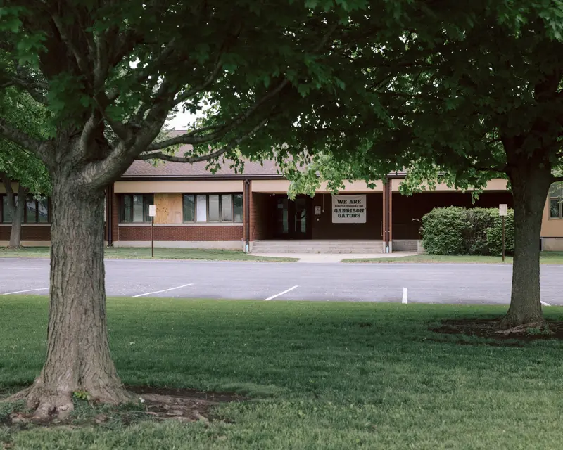 A low-slung brick building with a banner out front reading "We are Garrison Gators."