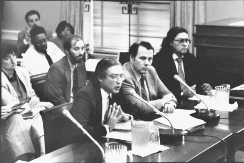 Black and white photograph of men in a courtroom, focused on Walter Echo-Hawk.