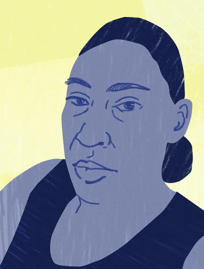 Portrait of a woman staring straight at the viewer, wearing a tank top and with her hair pulled back in a low bun.